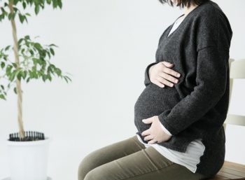 妊婦がお腹の赤ちゃんを大事に触る画像