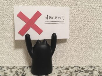 黒猫の人形がデメリットのカードを持っている画像
